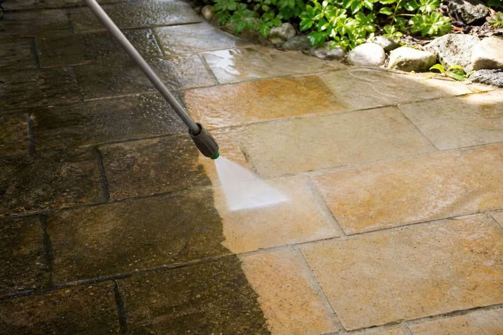 Power washing a stone patio showing the clean and dirty contrast
